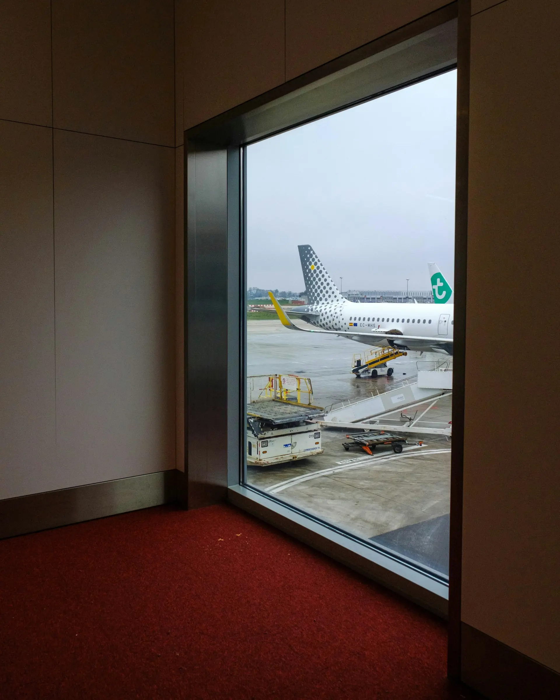 Airplane at the gate seen from an airport terminal window