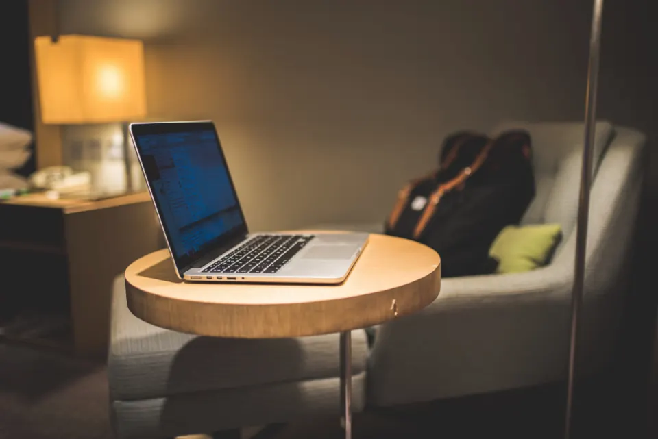 Hotel guest working on a laptop in a hotel room