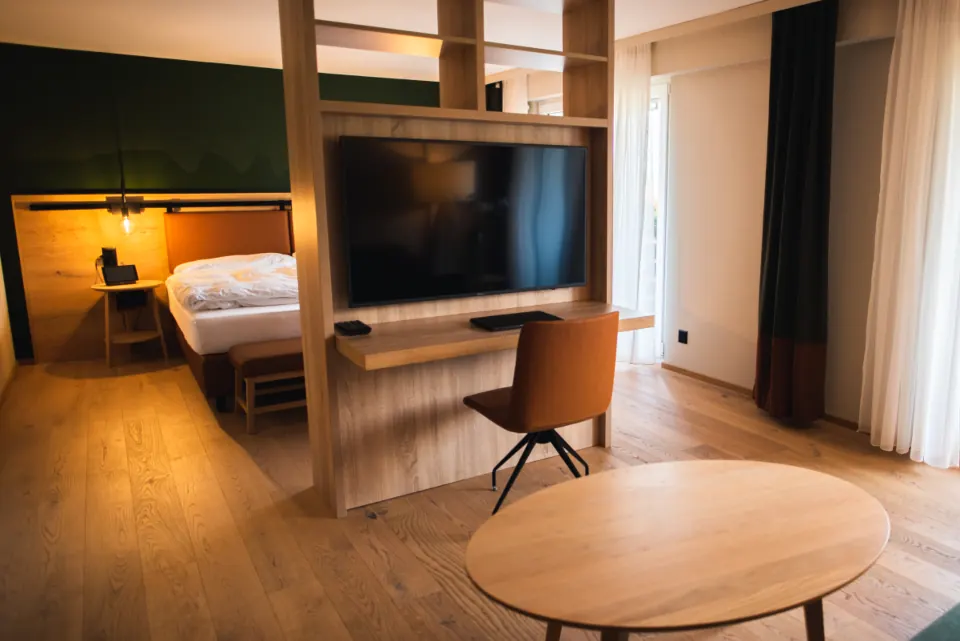 Modern hotel suite with a TV and desk