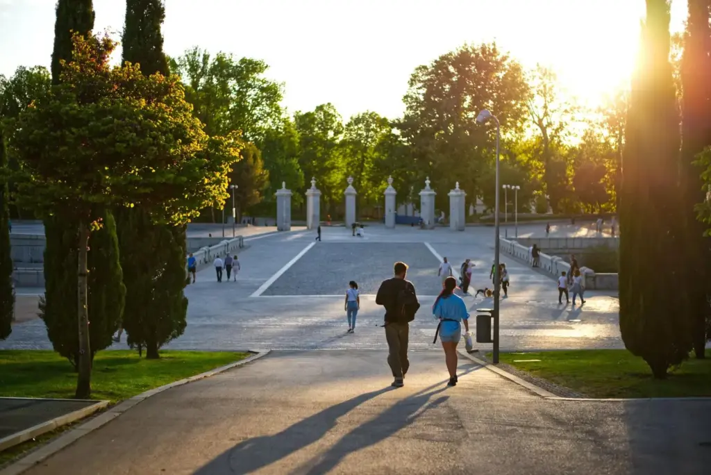 People walking through a Detroit park at sunset
